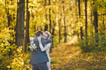Young couple hugging on the background of Sunny autumn forest.
