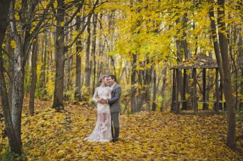 Portrait of beautiful young couple on the background of bright autumn forest.