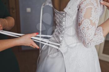 The process of dressing a wedding dress.