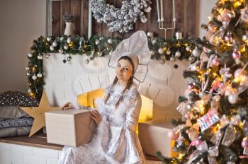Portrait of a snow Maiden at the new years decorated Christmas tree.