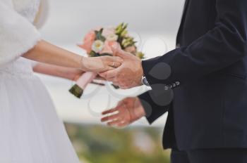 Newlyweds hold hands for a bouquet on both sides.