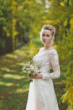 Girl in a beautiful modern wedding dress on the background of nature.