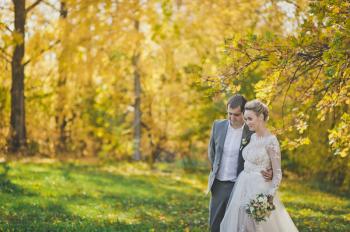 The bride and groom walking in the autumn forests paths.
