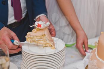 Young husband and wife to divide pieces of cake to treat your guests.