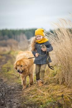 Walking baby with dog on autumn field of wheat.