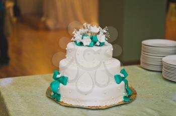 Huge sweet cake decorated with ribbons of mastic.