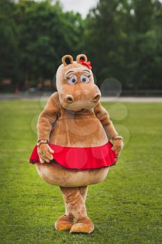 Animator in a Hippo suit on a green field.