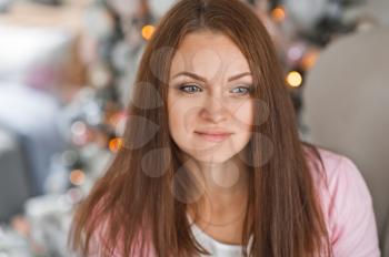 Girl with long brown hair at the Christmas tree.