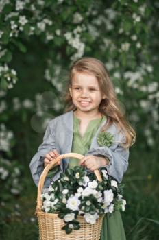 The child enjoys the spring and a basket of flowers in his hands.