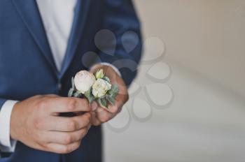 A man is holding a boutonniere.