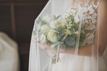 The bouquet of the bride under the veil.