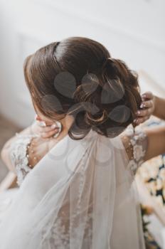 Beautiful photo of the bride during the creation of hairstyles.