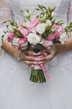 Beautiful bride bouquet in her hands closeup.