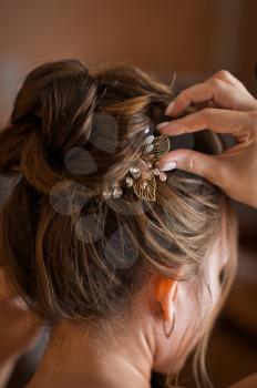 Model of wedding female hairstyle with jewelry.