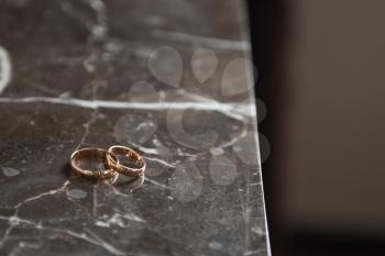 Wedding rings of the newlyweds on the holiday table.