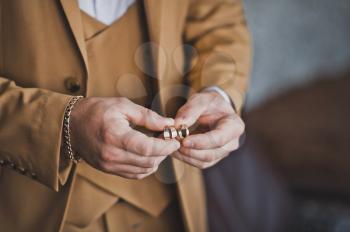 Hands of newlyweds with wedding rings.