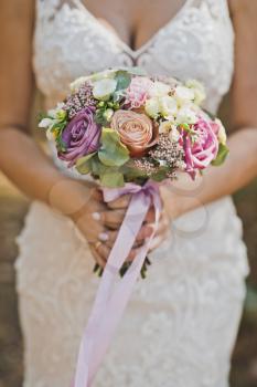 Delicate bouquet of pink and white flowers in the hands of the bride.