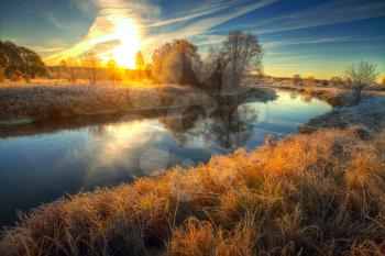 Dawn at the river .osen. frost on trees and grass