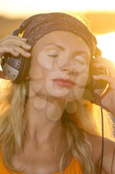 blonde girl DJ with headphones at the sea. Relaxation at sea