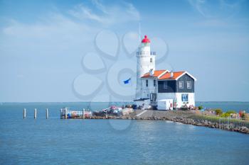 lonely lighthouse stands on the spit in the sea near the village of Marken. Near Amsterdam