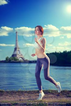 Redhead sexy girl running at sunset in the summer against the backdrop of the Eiffel Tower. Lifestyle