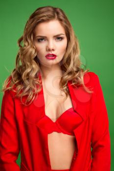 Sexy girl in red on a green background. in a jacket and skirt bra.