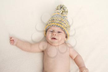 baby in a hat on the bed