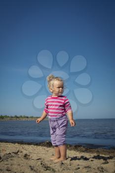 little girl walking by the sea. summer vacation by the ocean