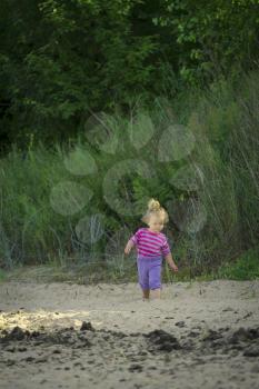 little girl walking by the sea. summer vacation by the ocean