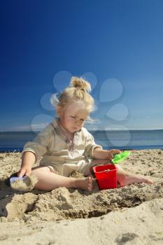 little girl playing in the sand on the beach by the sea. summer rest