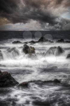 Storm in the ocean. Stones in the water are shot on a long exposure