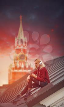 girl listening to music on the roof on the background of the Red Square in Moscow