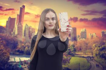 girl blogger shoots on a smartphone in the central park of New York