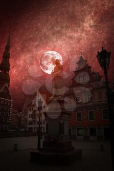 Riga Church of St. Peter and the streets of the ancient city. The red moon is shining.