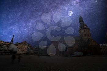 old houses on Riga street. Latvia. At night the moon and stars shine.