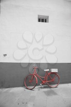 Red bicycle on a white wall background. black and red and white photo