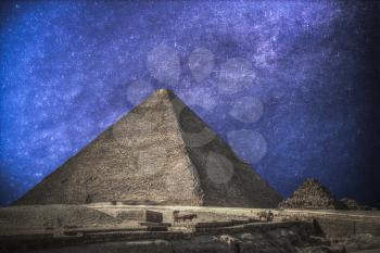 pyramids in Giza. Complex of ancient buildings in Egypt. Astrophotography. Night sky with stars.