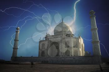 people stand in the archway and removed on the phone at the dawn of The Taj Mahal. Powerful lightning strike. 