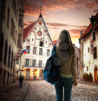 girl traveler stands with a backpack in the background of Tallinn