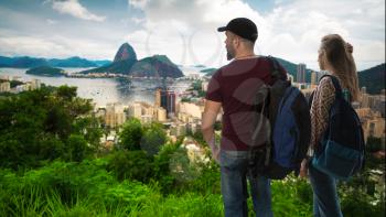 girl with a man travelers is standing with backpacks on the background of RIO