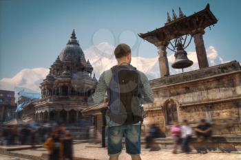 man traveler stands with a backpack in the background of Patan, Nepal