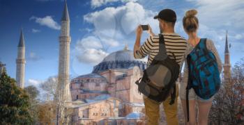 couple of travelers make a photo on a smartphone on the background of Istanbul. Hagia Sophia .