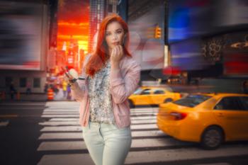 woman with red hair in New York paints lipstick lips