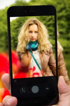 Photograph of a girl on a smartphone in the park