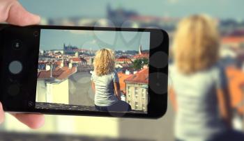 blogger shoots a smartphone sitting on the roof of a woman in Prague