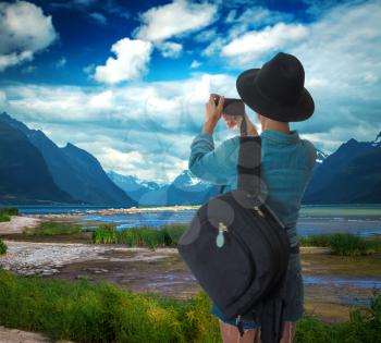 woman traveler photographs the landscapes of Norway.