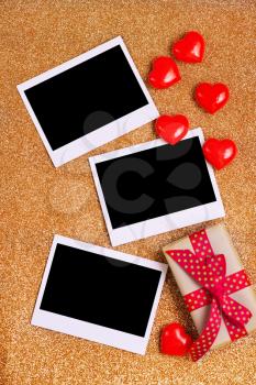 Blank instant photo and hearts on a table