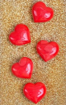 red hearts on a table, red hearts on golden background