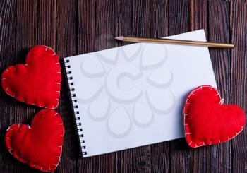 note book and hearts on the wooden table