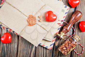 envelopes and red hearts on the wooden table
